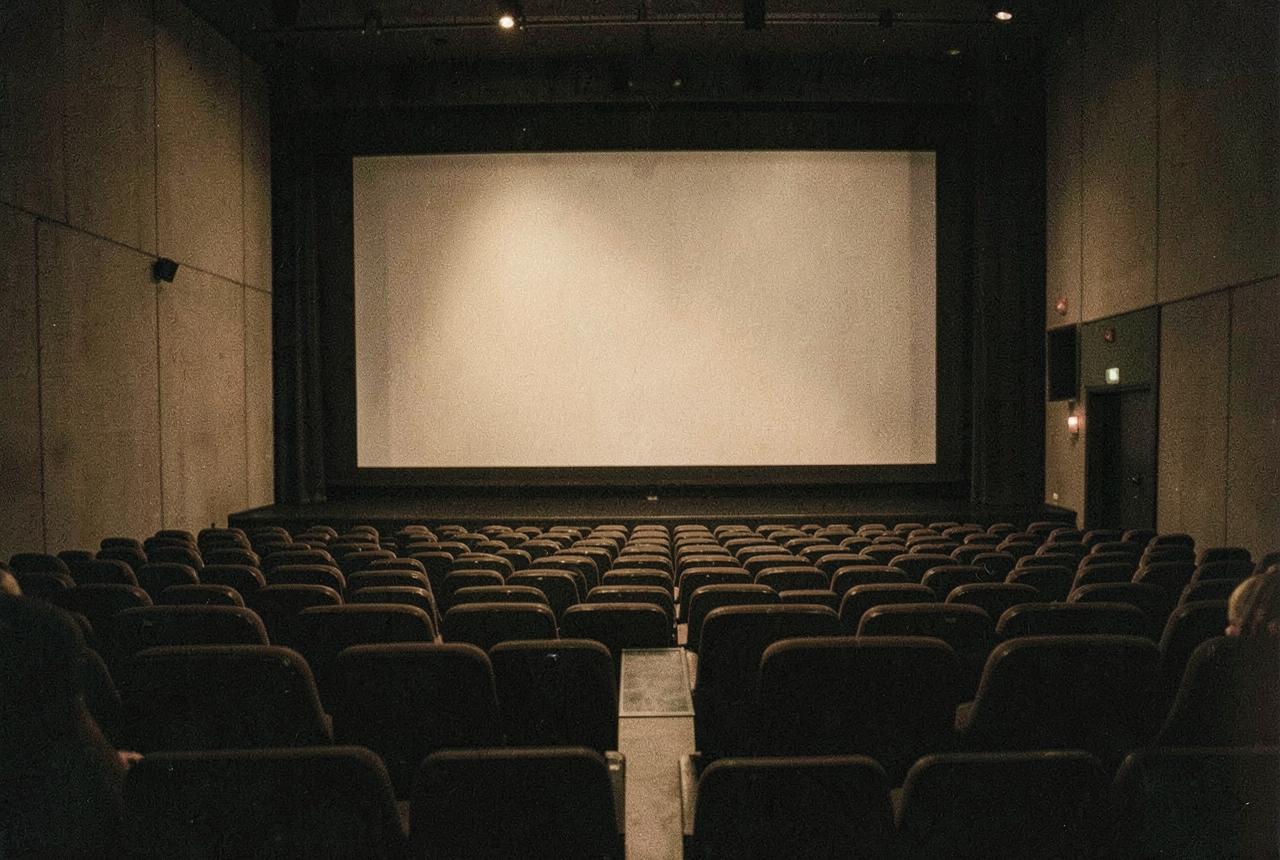An empty cinema auditorium lit softly from the screen
